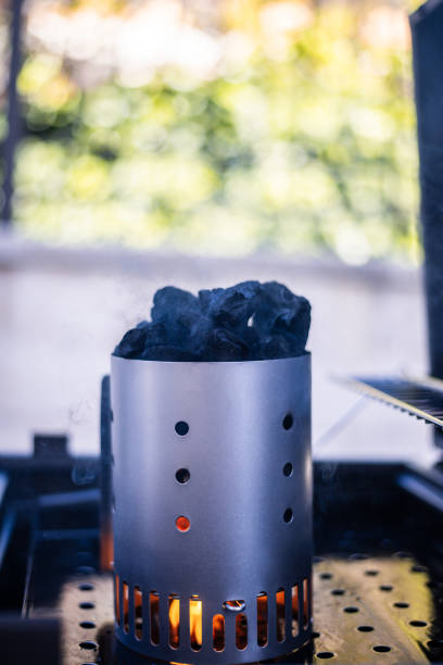 Device filled with charcoal and a fire at the base to prepare the coals for a tasty barbecue.