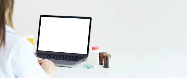istock Laptop mock up, Laptop computer with blank screen and medicines on docter table 2158947553