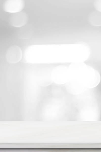 istock Vertical empty white table top, counter, desk over blur perspective store with bokeh light background, White marble stone table, shelf and blurred shop for food, product display mockup 2158947566