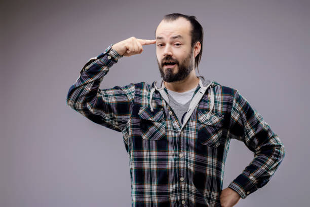 istock Bearded man pointing at his temple expressing thought 2158948709