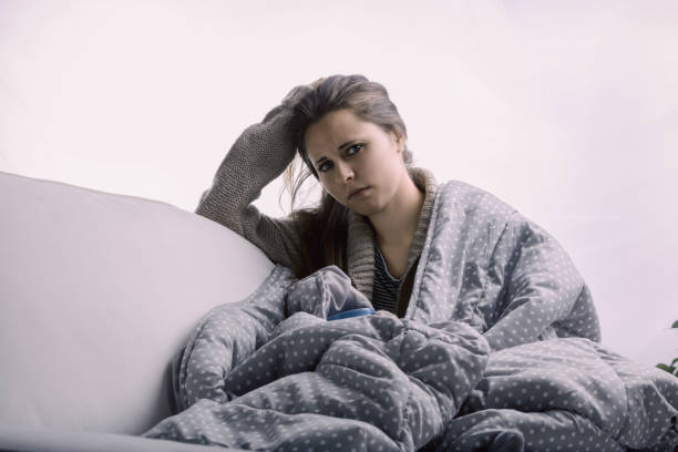 istock Young woman feeling sick and tired relaxing on sofa 2158949055