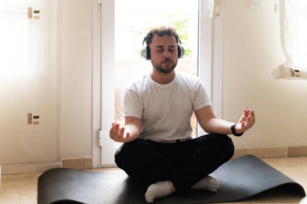 istock Young man relaxing at home with guided meditation 2158951084