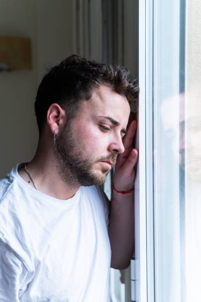 istock Serious concerned caucasian man looking through the window 2158951192