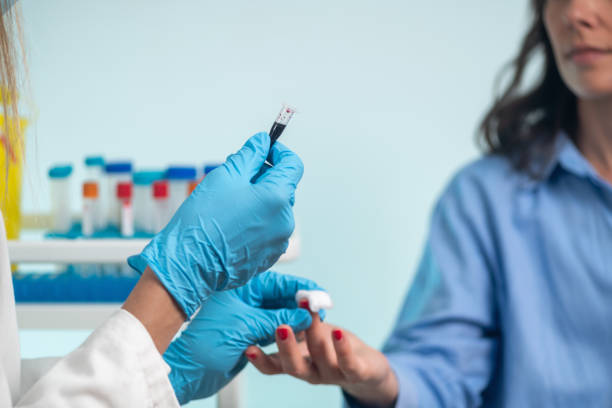 istock Nurse performs finger prick blood draw on patient for sample collection. 2158952057