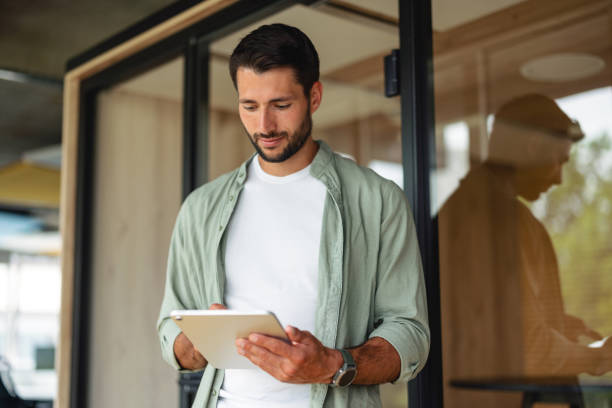 Portrait of Caucasian Businessman Using Digital Tablet in Modern Office