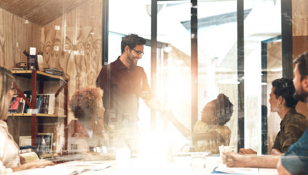 istock Group, business people or shaking hands with lens flare or double exposure, conversation with client for sales. Handshake, collaboration or team meeting in office with deal for company in city 2158953335