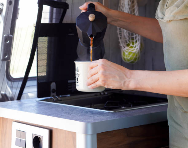 istock mother making coffee in the kitchen of a camper van 2158954178