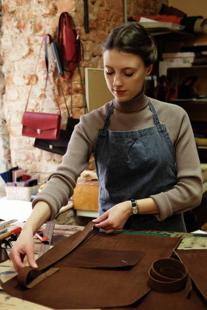 istock young woman works in a bag making studio, cuts out details 2158956188
