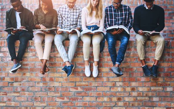 istock College student, group and books on wall with legs, learning and progress for development at campus. People, friends and scholarship for education, information and knowledge for future at university 2158956936