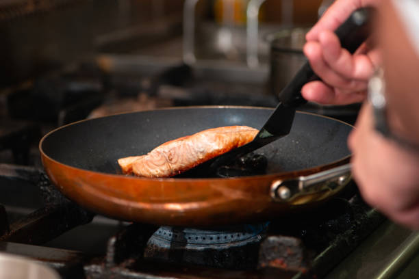 istock Chef cooking salmon in the frying pan 2158959939
