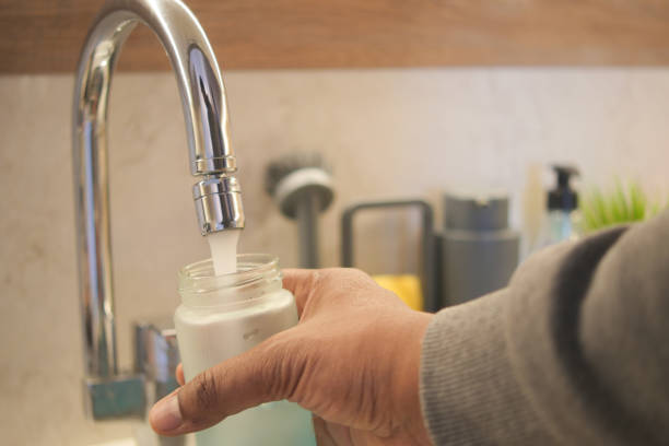 istock Filling a bottle with water from a faucet using hand gestures 2158962482