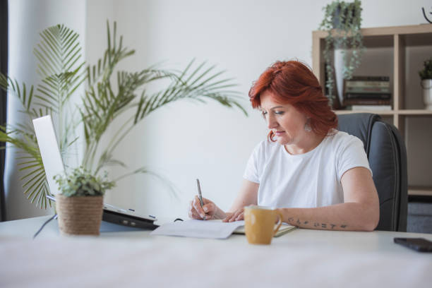 Mature business woman when taking notes in a notebook