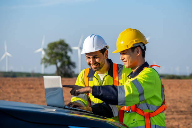 istock Diverse ethnicity male technicians working in the wind turbines field. Innovation engineer men use laptop computer work to develop environmental renewable clean energy outdoors at windmill power farm. 2158964519