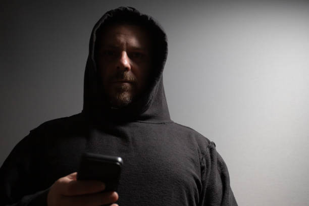istock Identity thief, a man with a phone, stealing personal data, posing as a burglar, threatening security. 2158964675