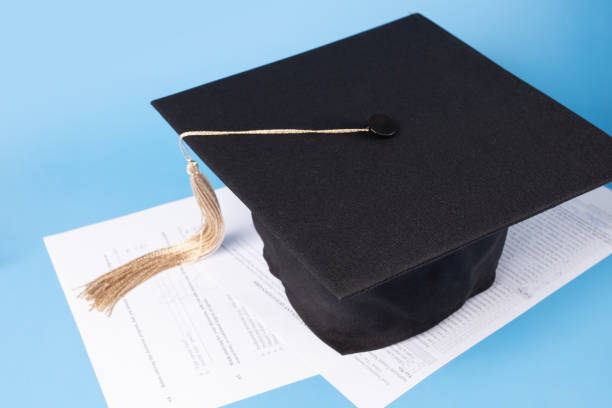 istock Education documents, graduation cap and exam papers, graduate receiving diploma, high school ceremony, academic success 2158964825