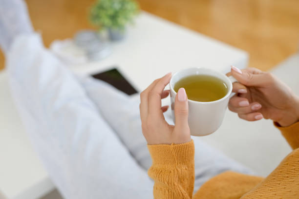 Woman resting in sofa with cup of tea