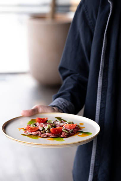 istock restaurant waiter bringing food 2158968457
