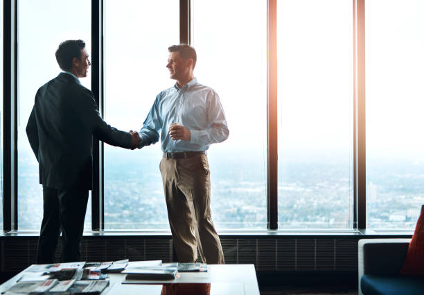 Men, handshake and window in office for partnership, greeting and onboarding in modern workplace. Deal, support and business people in Seattle for collaboration, welcome and agreement for project It was a pleasure doing business with you office buddies stock pictures, royalty-free photos & images