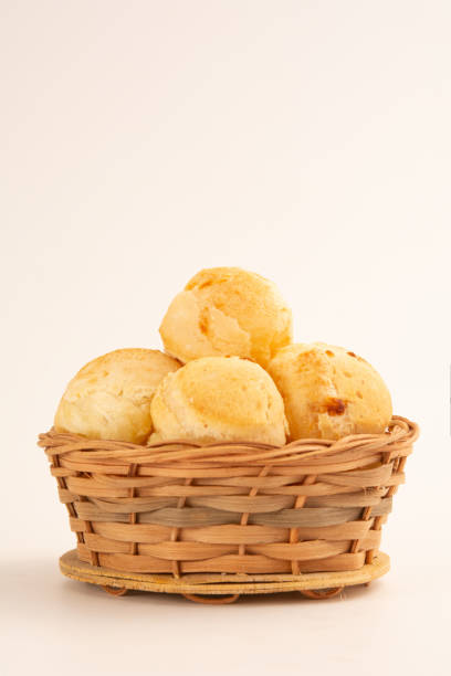 Brazilian cheese bread inside a wooden basket in a white clean background in front view