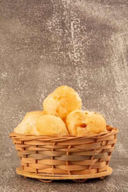 istock Brazilian cheese bread inside a wooden basket in a cement background in front view 2158974189