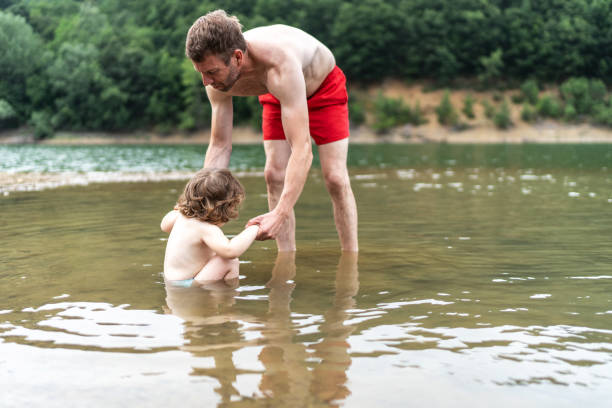 istock Cute kid having fun with her father in the lake 2158975683