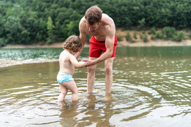 Cute kid having fun with her father in the lake