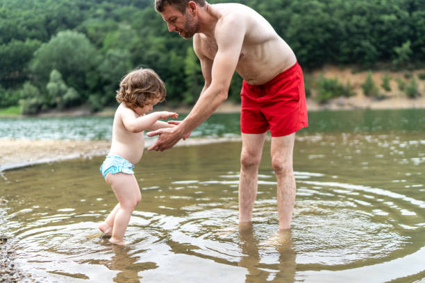 Cute kid having fun with her father in the lake