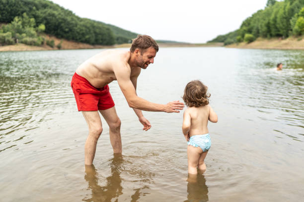 istock Cute kid having fun with her father in the lake 2158975932