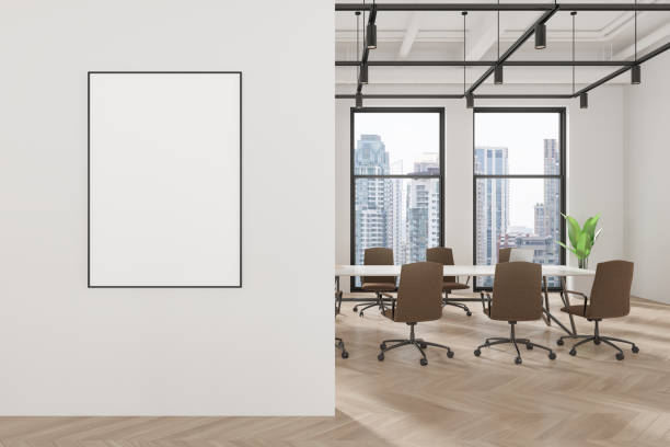 istock White office interior with meeting table and chairs, window and mockup frame 2158976934