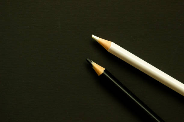 black and white pencils on a black plain background, contrast, school supplies, concept