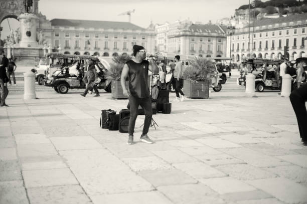 Lisbon, Portugal - Mars 16, 2024: A street musician sings at the Praça do Comércio square in Lisbon downtown.