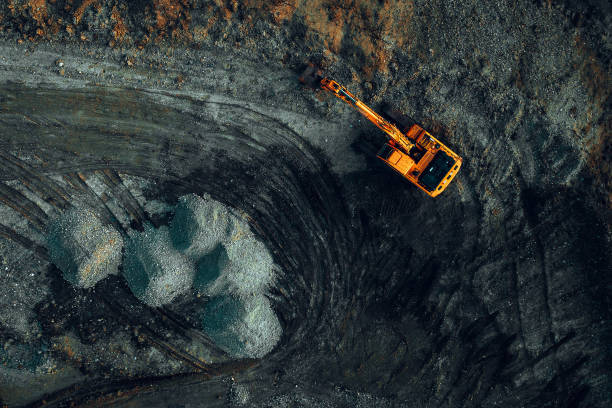 istock bright excavator at work on a dark background view from a drone 2158980390
