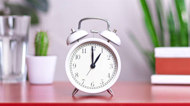 istock Classic white clock on a table. The clock hand points to 1 or 13, close up 2158981839