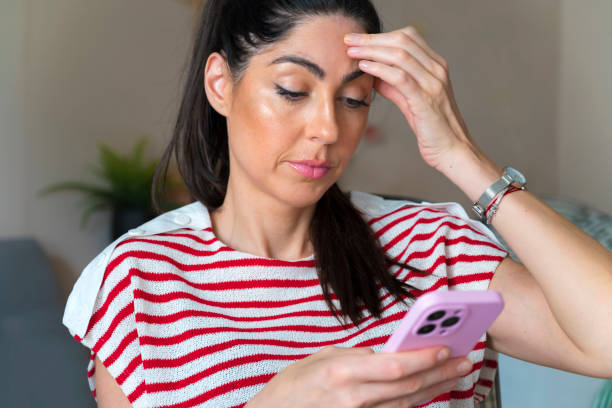 istock Worried  Woman using her phone at home 2158982295