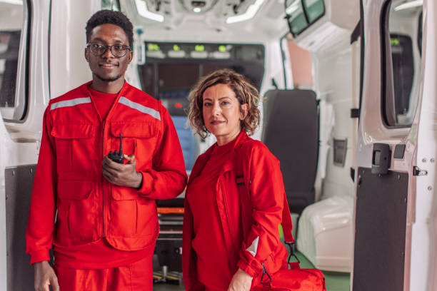 istock Two paramedics standing inside ambulance holding medical equipment 2158984782