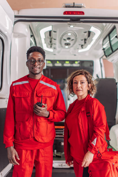 istock Two paramedics standing near open doors of an ambulance 2158984818