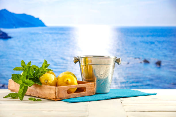 Fruit and sea and summer table background. Lemons on wooden white board table top in summer. Copy space for products and food and drink.