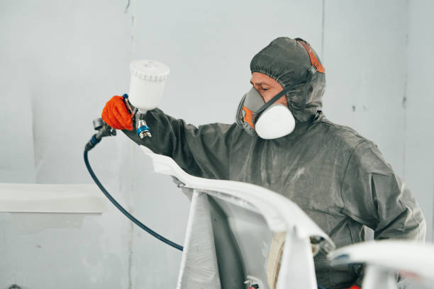 istock Auto painter painting a car with vaporizer gun inside a paint booth 2158989170