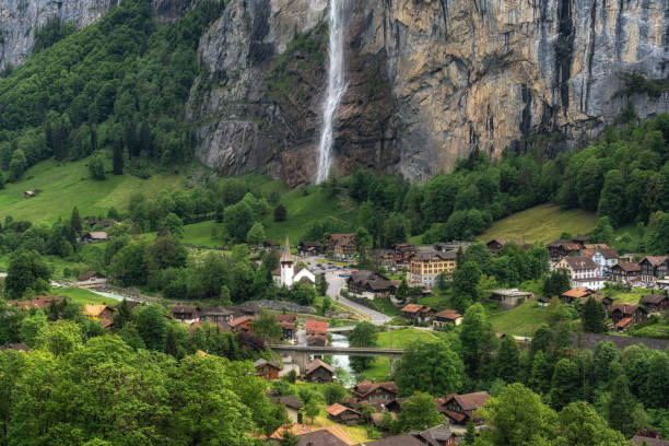 View of Lauterbrunnen village and Staubbach Waterfall. Famous tourist attraction in Bernese Oberland, Switzerland