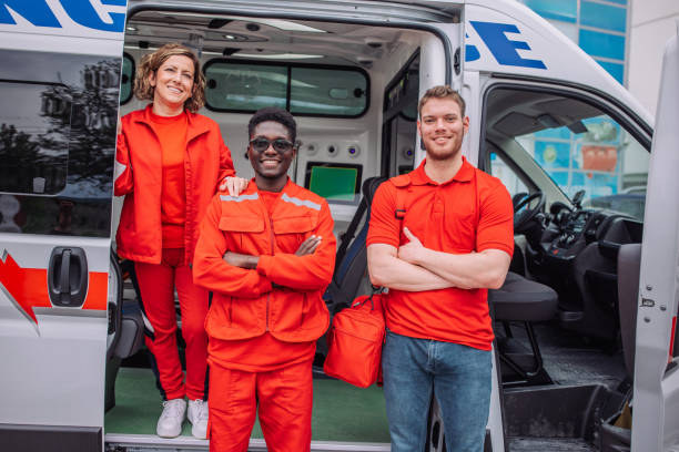 istock Smiling paramedics posing with arms crossed by ambulance 2158992017