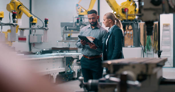 Robotics, staff and tablet engineer inspection with industrial teamwork and check in warehouse. Factory, engineering and futuristic work of manufacturing management with discussion for cnc automation