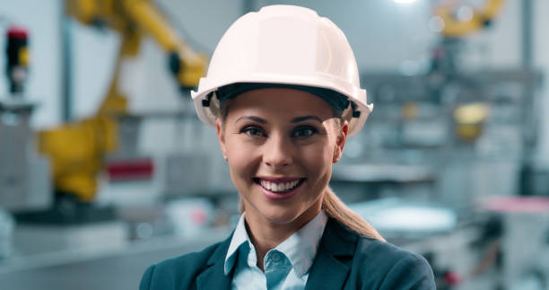 istock Portrait, technician and woman with hard hat, robotics and maintenance in factory, programming and protection. Face, person or employee with helmet, inspection or engineering in workshop for industry 2158997940