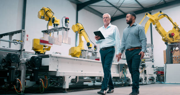 istock Men, tablet and robotic machinery in factory for construction support, research and inspection of automation production. Engineer team, digital and innovation, collaboration and robotics project site 2158997947