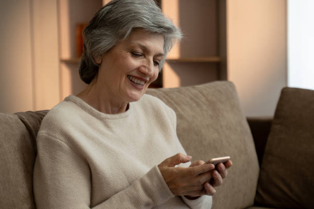 istock Senior Woman Using Smartphone On Couch At Home 2159001582