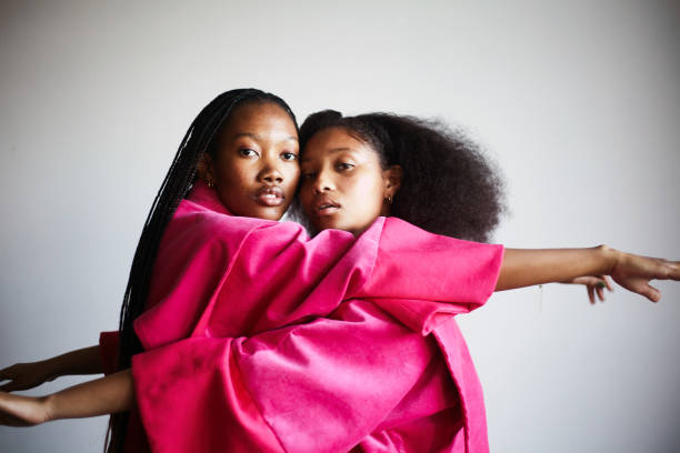 Two models embracing each other in designer clothes in studio