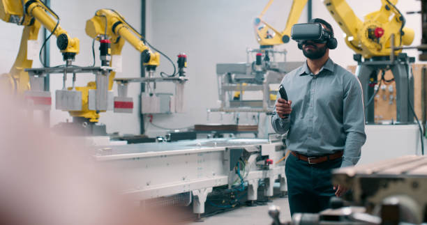 istock Robotics, engineering and man with virtual reality for futuristic manufacturing, production or programming Automation technician in workshop with joystick, VR glasses and CNC machine in industry 4.0 2159002972