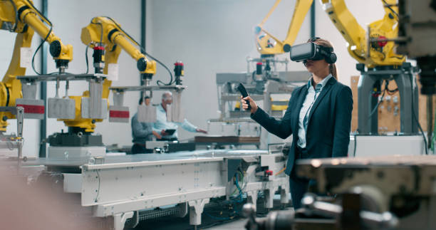 istock Robotics, engineering and woman with virtual reality for futuristic manufacturing or programming of industry 4.0. Automation technician in workshop with joystick and VR glasses for CNC machinery 2159002980