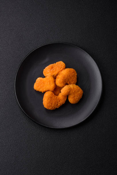 istock Delicious fresh crispy chicken nuggets on a dark concrete background 2159003188