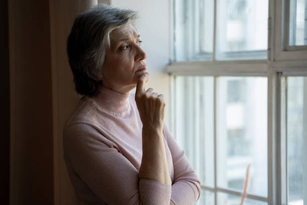 istock Senior Woman Contemplating By Window During Daytime 2159003803