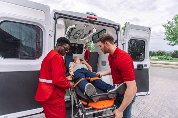 istock Paramedics moving patient on stretcher into ambulance 2159003807